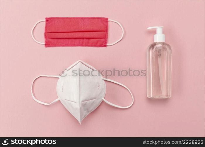 top view medical masks with disinfectant bottle