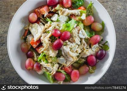 top view mix salad with grapes and chicken on white dish. Mix salad