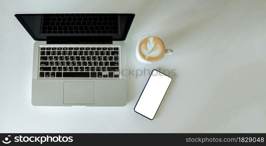 Top view mock up smartphone with mouse computer laptop and coffee cup.Copy space flat lay.