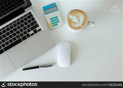 Top view mock up smartphone with mouse computer laptop and pen and coffee, calculator.Copy space flat lay.