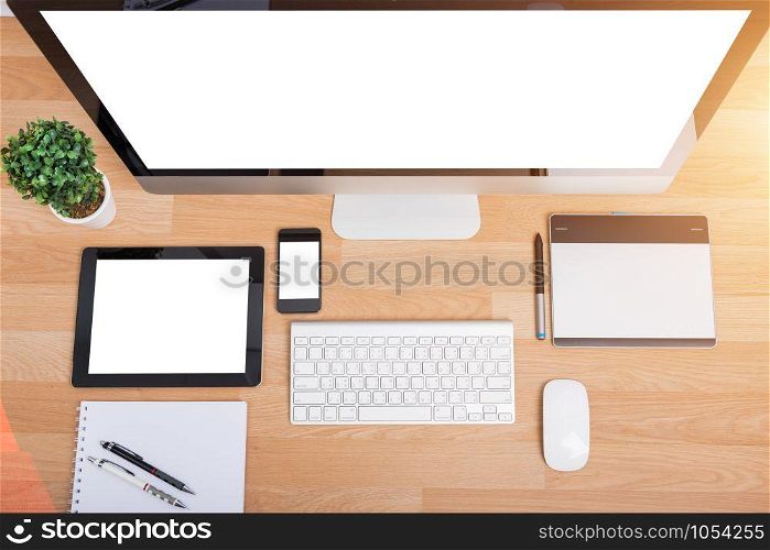 Top view monitor computer PC, keyboard, Phone, magic mouse and tablet on wooden desk