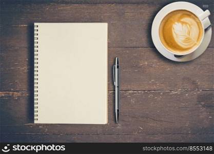 Top view notebook and pen with coffee cup on wood table, Vintage filter.