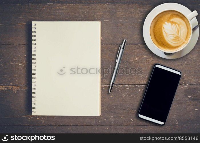 Top view notebook, pen, coffee cup, and phone on wood table, Vintage filter.