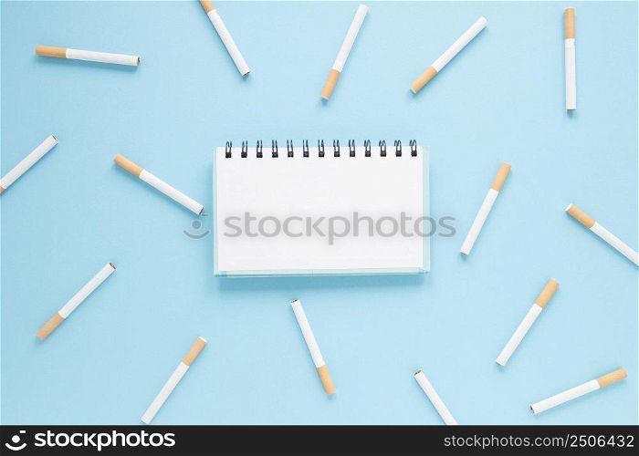 top view notebook surrounded by cigarettes