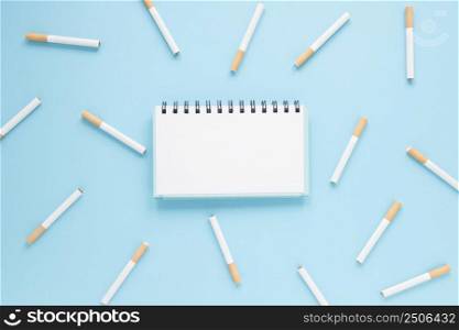 top view notebook surrounded by cigarettes