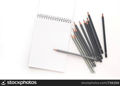 Top view, notebook with pencils on a white background.. Notebook with pencils on a white background. Top view