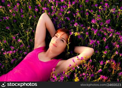 Top view of a beautiful young woman lying on a flowery meadow
