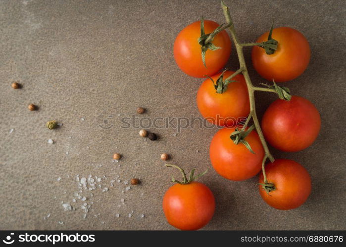Top view of a bunch of natural cherry tomatoes on cement background with copy space.