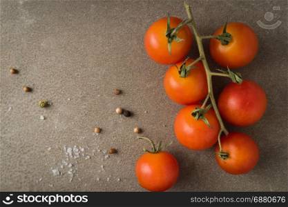 Top view of a bunch of natural cherry tomatoes on cement background with copy space.