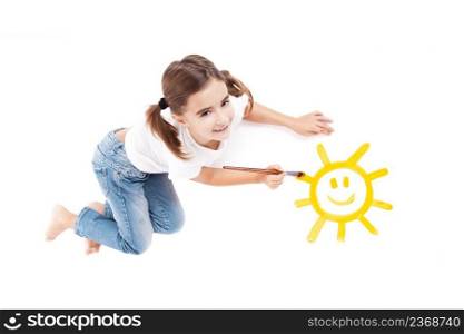 Top view of a happy girl lying on floor and painting a happy sun