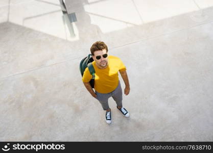 Top view of a male student on the university campus. Young man in urban background.. Top view of a male student on the university campus.