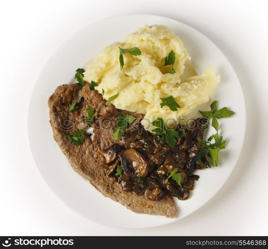 Top view of a meal of a fried veal escalope with sauteed mushrooms and mashed potatoes.