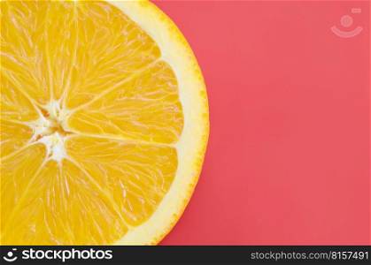 Top view of a one orange fruit slice on bright background in red color. A saturated citrus texture image