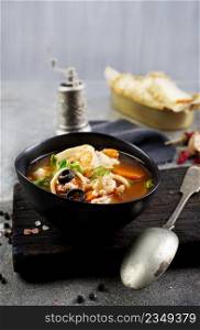 Top view of a plate with Pan Asian traditional seafood soup with mussels, calamari, mushrooms. Pan Asian traditional seafood soup with mussels, calamari, mushrooms served with fresh parsley herbs