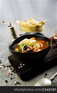 Top view of a plate with Pan Asian traditional seafood soup with mussels, calamari, mushrooms. Pan Asian traditional seafood soup with mussels, calamari, mushrooms served with fresh parsley herbs