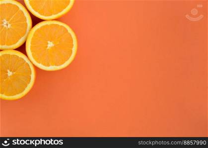 Top view of a several orange fruit slices on bright background in orange color. A saturated citrus texture image