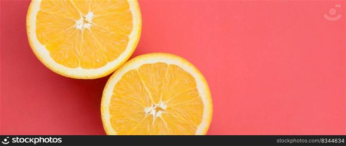 Top view of a several orange fruit slices on bright background in red color. A saturated citrus texture image