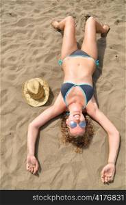 top view of a slim woman is lying on the beach