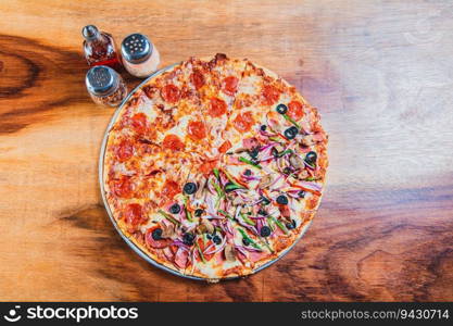 Top view of a supreme mixed pizza on wooden table. High angle view of mixed supreme pizza on wooden table