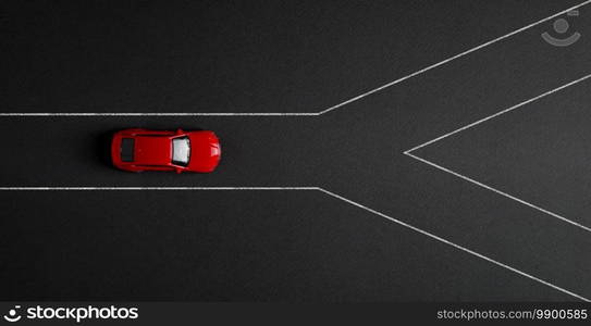 Top view of a toy car standing at a crossroads. Indecision, choice making concept