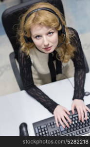 top view of a young smiling female call centre operator doing her job with a headset