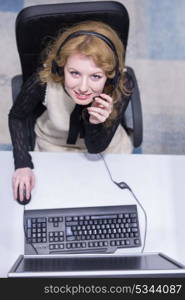 top view of a young smiling female call centre operator doing her job with a headset