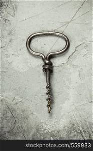 Top view of an old cork screw on gray concrete background with space for text