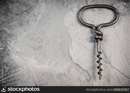 Top view of an old cork screw on gray concrete background with space for text