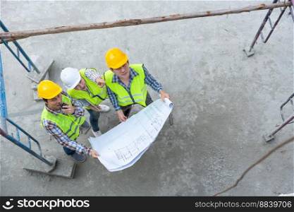 Top view of Asian engineer or Young Female Architect put on a helmet for safety and talk with a contractor on a construction building factory project, Concept of Teamwork, Leadership concept.