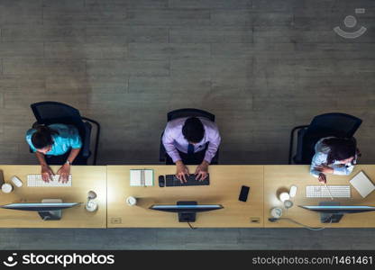 Top view of Asian Male customer care service working hard late in night shift at office,call center department,worker and overtime,team work with colleagues for success concept