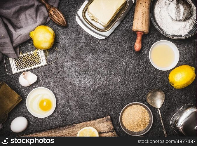 Top view of bake preparation with kitchen tools and ingredients for cake or cookies : lemon , flour, egg, raw sugar and butter on dark rustic kitchen table background, top view, frame