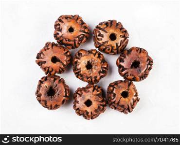 top view of beads from natural seeds of Rudraksha tree on gray concrete background