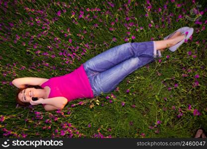 Top view of beautiful young woman lying on the nature and talking at cellphone