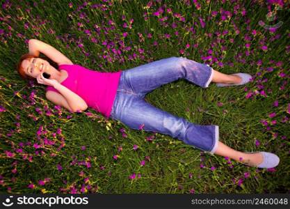 Top view of beautiful young woman lying on the nature and talking at cellphone 