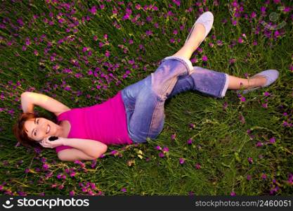 Top view of beautiful young woman lying on the nature and talking at cellphone