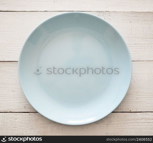 Top view of blue plate on a wooden background