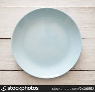 Top view of blue plate on a wooden background
