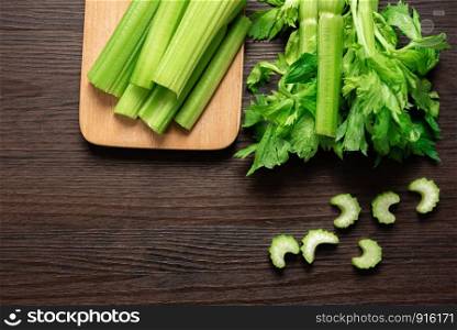 Top view of bunch of fresh sliced celery stalk on wooden table with leaves. Food and ingredients of healthy vegetable. Freshness herbal and low calories for dieting with plenty of vitamin