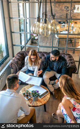 Top view of business people in an informal work meeting sitting on the couch. Top view of informal work meeting sitting on sofa