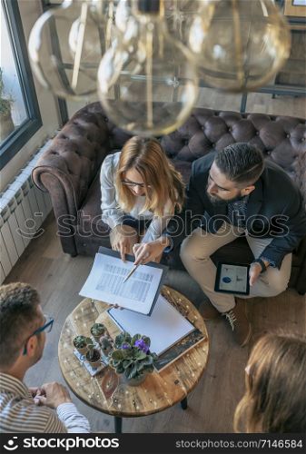 Top view of business people in an informal work meeting sitting on the couch