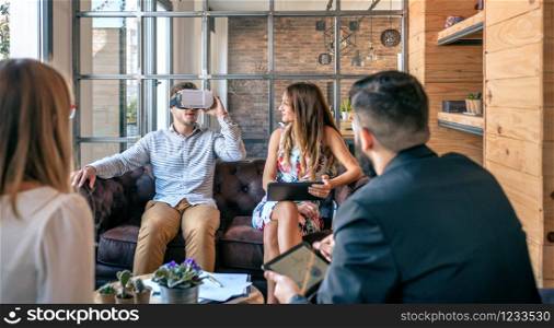 Top view of business people in an informal work meeting using virtual reality glasses. Businessman using virtual reality glasses