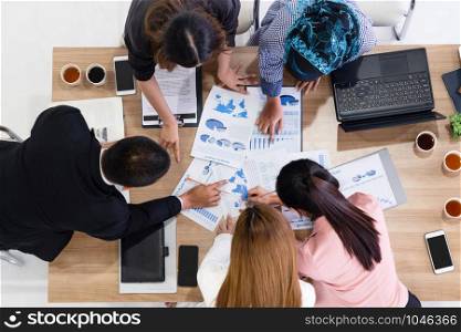 Top view of businessman executive in group meeting with other businessmen and businesswomen in modern office with laptop computer, coffee and document on table. People corporate business team concept.