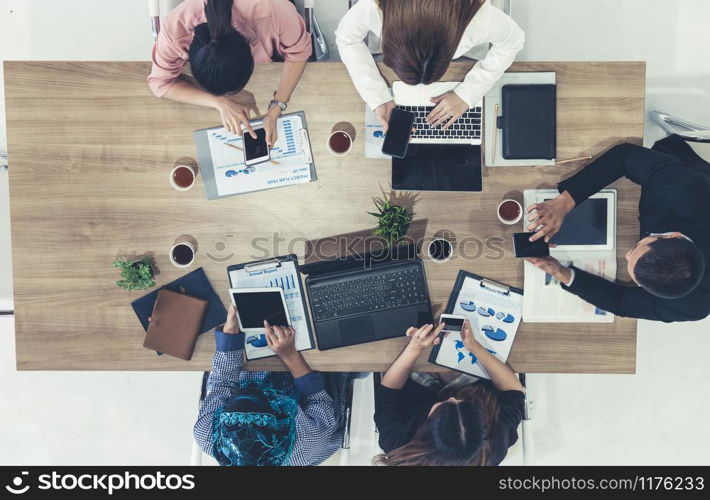 Top view of businessman executive in group meeting with other businessmen and businesswomen in modern office with laptop computer, coffee and document on table. People corporate business team concept.