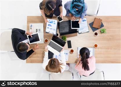 Top view of businessman executive in group meeting with other businessmen and businesswomen in modern office with laptop computer, coffee and document on table. People corporate business team concept.