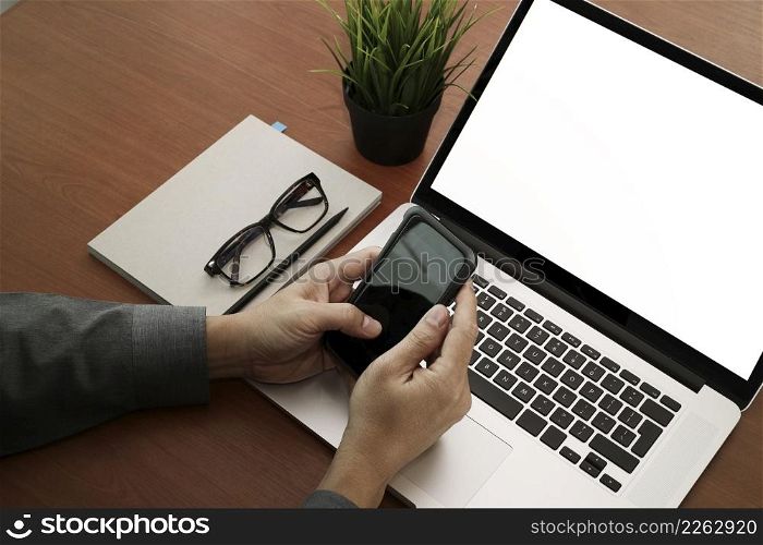 top view of businessman hand using on smart phone and laptop computer as concept