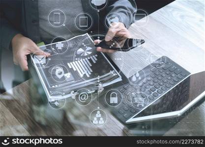 top view of businessman hand using smart phone,mobile payments online shopping,omni channel,digital tablet docking keyboard computer,documnets,in modern office on wooden desk,virtual interface icons screen