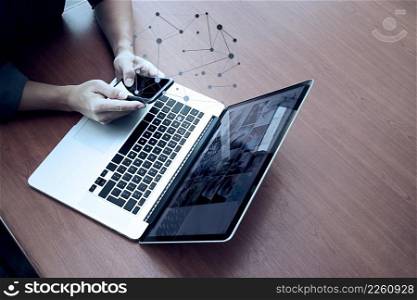 top view of businessman hand working with new modern computer and smart phone and business strategy on wooden desk as concept  