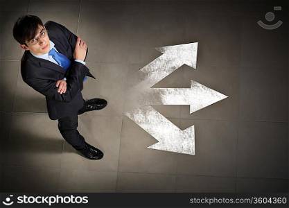 Top view of businessman standing against directions background