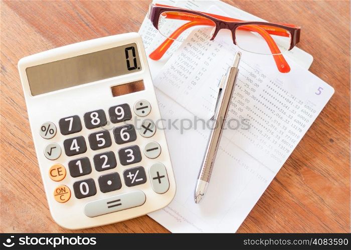 Top view of calculator, pen, eyeglasses and bank account passbook, stock photo