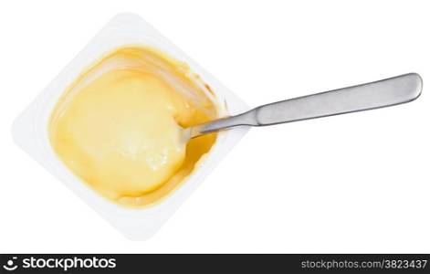 top view of caramel yoghurt and spoon in disposable plastic cup isolated on white background